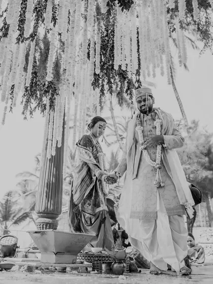 A timeless black and white photograph of the couple during their Maharashtrian wedding pheras. This artistic choice highlights the emotion and solemnity of the sacred ritual.