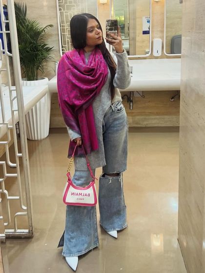 A cozy and chic winter look with ripped wide-leg jeans and a bright pink shawl for a pop of color.