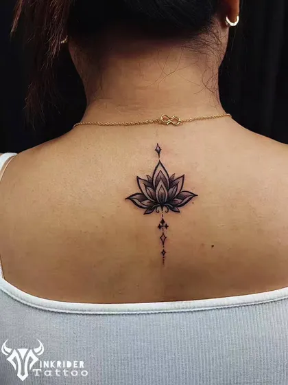 A beautifully shaded lotus tattoo placed on the upper back. The design incorporates geometric elements, giving this classic symbol of purity a modern and ornamental feel.