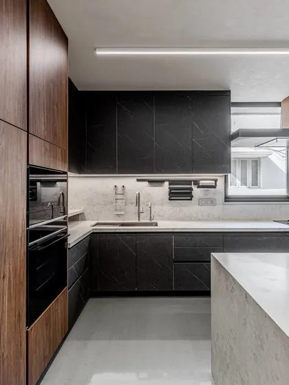 The interplay of light and shadow on the matte black and walnut finishes gives this kitchen a dynamic and sophisticated feel, perfect for a modern home.