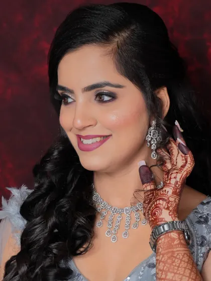 A happy, smiling client showing off her party makeup. The diamond jewelry and soft curls complete the look.