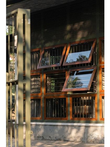 The 'Olive Dwelling' by Studio 3am uses louvered wooden windows to control light and airflow, a key feature of its rustic and climate-responsive design.