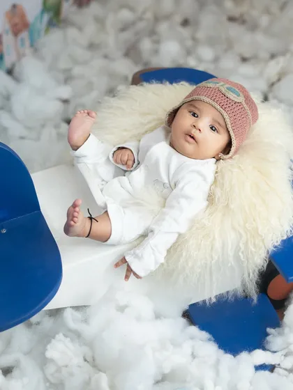 Our little pilot, complete with an aviator cap, is ready for his next adventure. The prop plane and cloud-like cotton create a dreamy, imaginative scene.