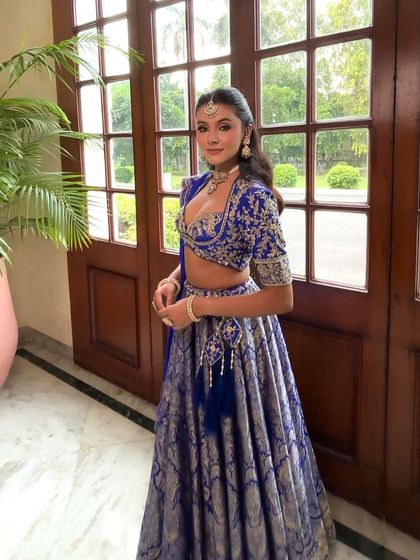 A full length shot of the client in her beautiful blue lehenga. The half updo hairstyle is elegant and doesn't overpower the intricate outfit.