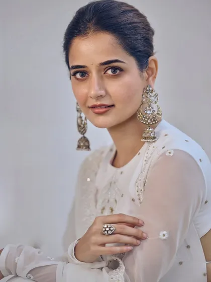 As seen on the graceful actress Ashika Ranganath, this off-white chikankari georgette Anarkali is all about understated elegance. The design features delicate self-pearls, a bandhgala neckline, and an open-back detail, making it a sophisticated choice for any special occasion.
