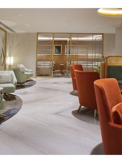The main lounge at the 'Reserved Lounges' in Bangalore, featuring custom-designed furniture in green and rust red. The curved sofas are a key feature, providing both comfort and a sense of privacy for VVIP guests.