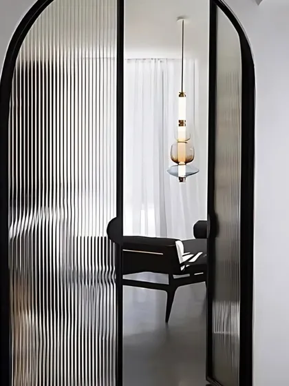 This image showcases a beautiful arched doorway with fluted glass, a key trend for 2025. This design element adds architectural interest while allowing light to pass through, creating a sense of openness between spaces.