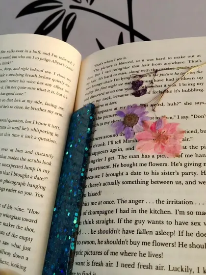 The blue glitter bookmark shown inside the popular novel 'It Ends With Us', a perfect accessory for fans of the book.