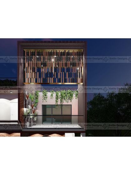 A close-up detail of the Twin House facade at night. This view highlights the intricate metal screen on the upper level, which provides privacy while creating a beautiful light pattern, adding a decorative element to the contemporary design.