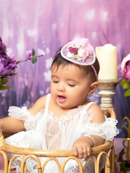 A candid moment as the baby looks down, captured during the dreamy lavender floral session.
