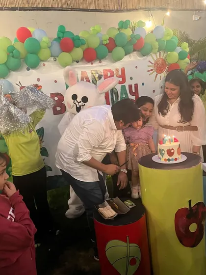 The birthday girl celebrates her "Hungry Caterpillar" party with a cake and a visit from our Hoppers bunny mascot.