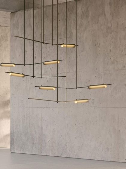 A close-up of the Volant chandelier's equilibrium. Solid brass bars hold the glass elements at precise angles, creating a fixture that feels both enthralling and soothing.