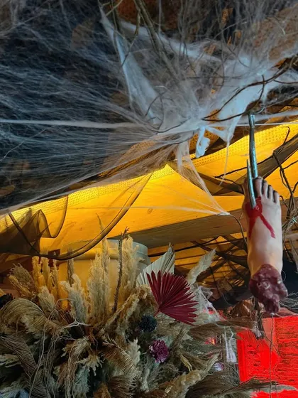 A gory and spooky detail for a Halloween party: a fake severed foot hangs from the ceiling.