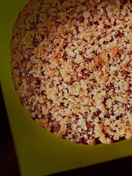A close-up, top-down view of the apple cinnamon cake, showing the beautiful texture of the buttery coconut oats crumble.