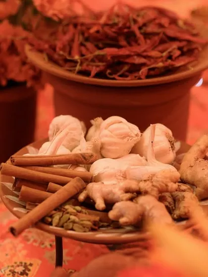 A tablescape that tells a story of the region, using spices like dried red chilies, cinnamon, and whole garlic as unique and aromatic decor elements.