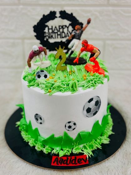 Another view of the dynamic football cake, showing the details of the players and soccer balls.