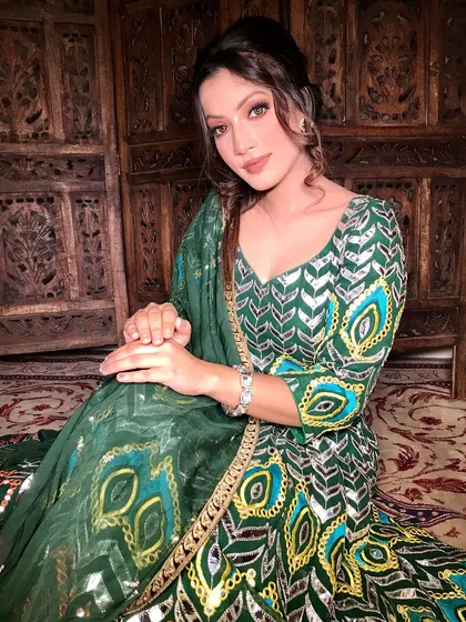 A full view of this elegant green suit and the complementary warm-toned makeup.