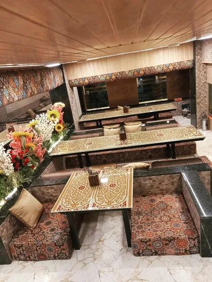 A wide view of the Dastarkhwan seating arrangements, showing how I can accommodate multiple groups for private and comfortable dining. The floral decorations add a touch of elegance.