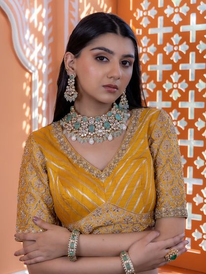 A model wearing our mint green and pearl Kundan bridal set. The soft colors and elegant design create a look of royalty, perfect for a daytime wedding or a bride who prefers a lighter color palette.