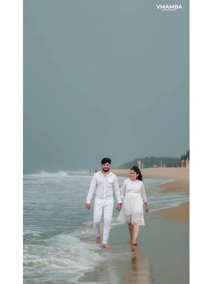 A vertical shot capturing a couple's walk on the beach, emphasizing the peaceful atmosphere. This composition is great for showcasing the environment.