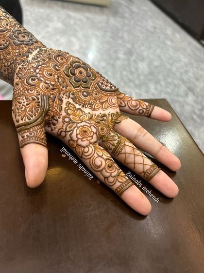 A different perspective on Zoya's engagement henna, highlighting the delicate work on the fingers and the main floral motif on the palm.
