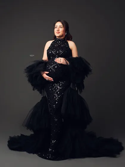 A full-length portrait of a mamma-to-be in a stunning black sequin and tulle gown. This is the epitome of a glam maternity shoot.