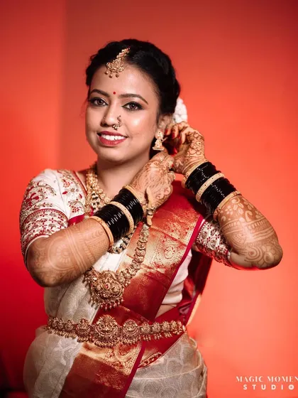 A beautiful portrait of the bride, Lavanya, adjusting her earring. This candid-style pose feels natural and elegant.