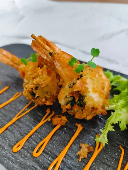 A perfect bite of seafood heaven. The golden panko coating gives way to a punchy chimichurri filling and a juicy prawn, creating a delightful contrast of textures and tastes.
