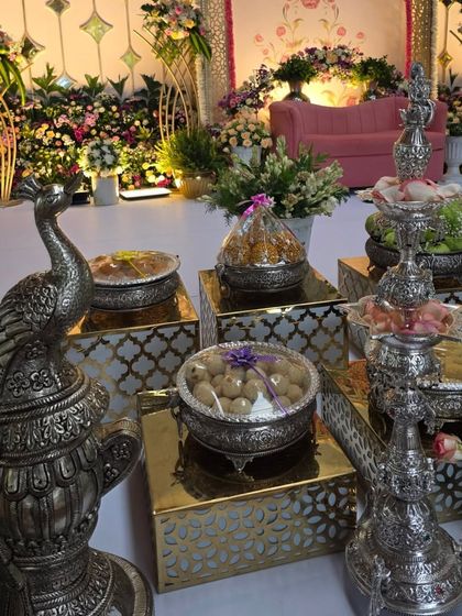 A close-up of ornate silver peacock and hookah-style props used for decoration.