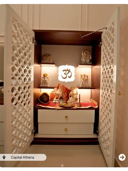 A compact and elegant pooja cabinet with latticework doors. The warm interior lighting highlights the idols, creating a beautiful and sacred focal point.
