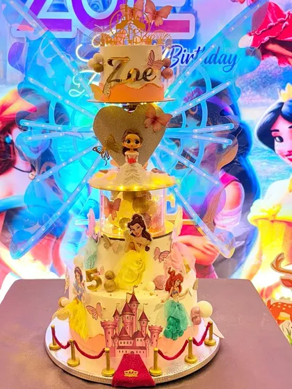 The same grand princess cake seen at the party, surrounded by a dazzling themed backdrop.