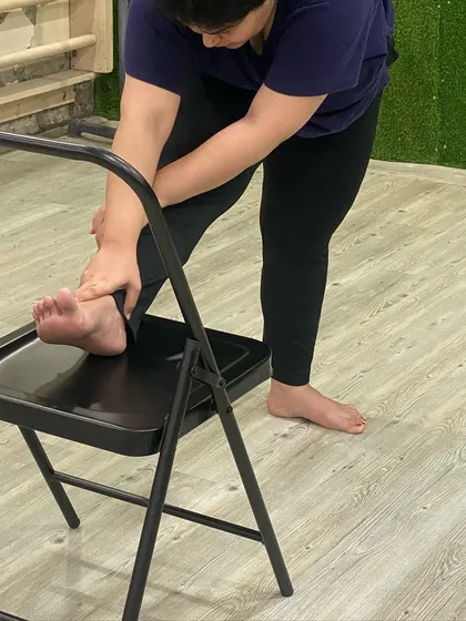 A close-up of a seated forward stretch, perfect for releasing tight hamstrings.