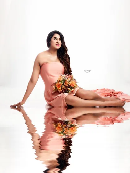 This elegant seated pose in a peach gown is enhanced by the clean white background and the beautiful water reflection I create in the studio, adding a touch of magic.
