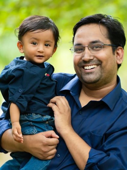 A proud father holding his son. The genuine smiles are what make these outdoor family portraits so special.