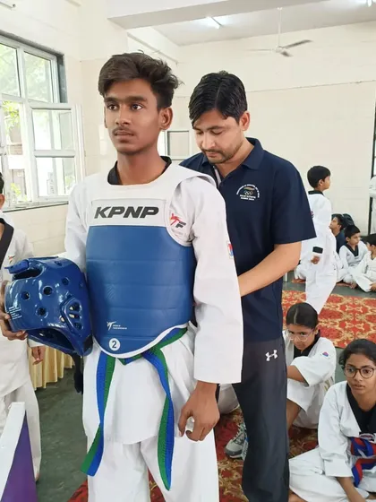 I believe in providing personal attention to every student. Here, I am helping a young fighter get his gear ready for the 11th South East District Taekwondo Championship.