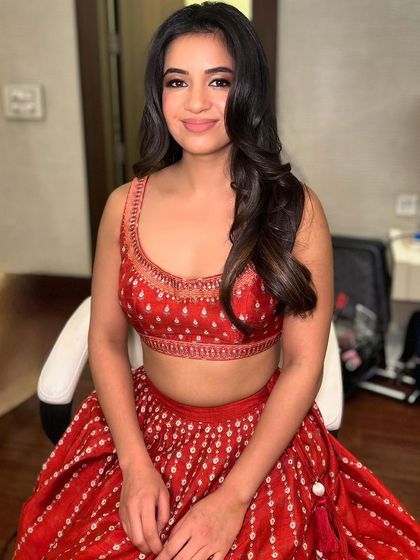 The final look of our client, smiling and confident. The combination of soft waves and glowing makeup makes for a perfect wedding guest look.