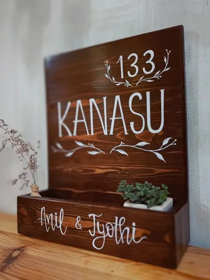 We love combining beauty with function. This custom wooden name plaque, "Kanasu," which means 'dream,' features a built-in planter box, adding a touch of green life to a family's entrance.