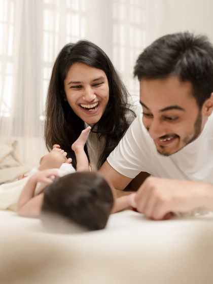 Pure, unscripted joy. The candid laughter of new parents as they play with their baby captures the happiness of these first few weeks.