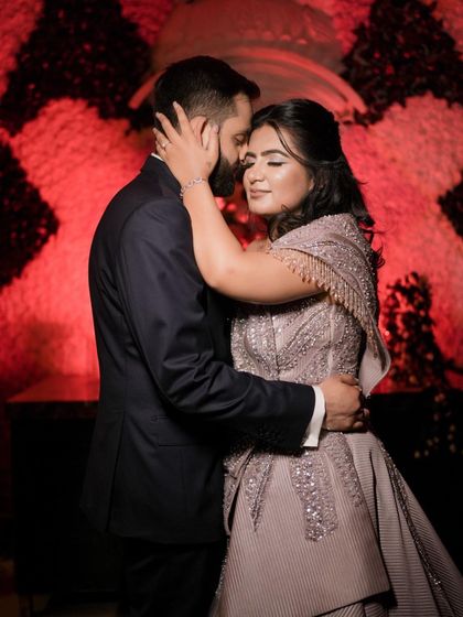 An intimate and emotional embrace captured with dramatic lighting, highlighting the intricate details of the bride-to-be's gown and the deep connection between the couple.