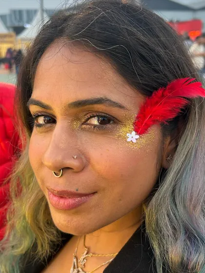 A touch of gold glitter with a red feather and a tiny flower. This look is so unique and shows how you can incorporate other elements into face art.