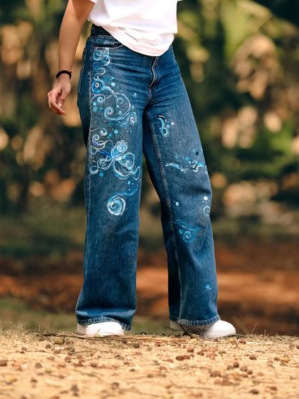 I gave my old, favorite pair of jeans a cosmic makeover. I painted them with swirling blue and white patterns that evoke a sense of space and movement, turning them into something truly unique.