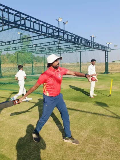 A coach demonstrates the correct body position and arm action for an accurate throw during a fielding session.