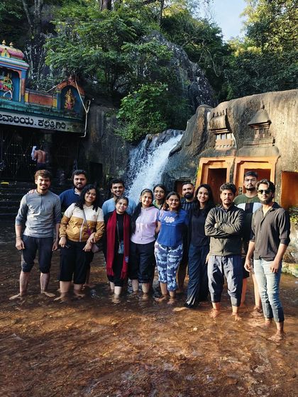 Our group standing in the water at the base of a temple waterfall in Chikmagalur.