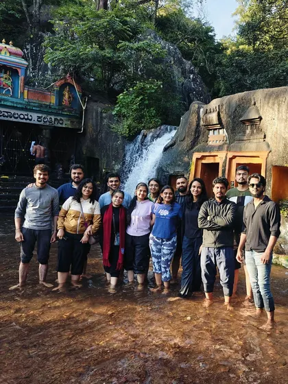 Our group standing in the water at the base of a temple waterfall in Chikmagalur.