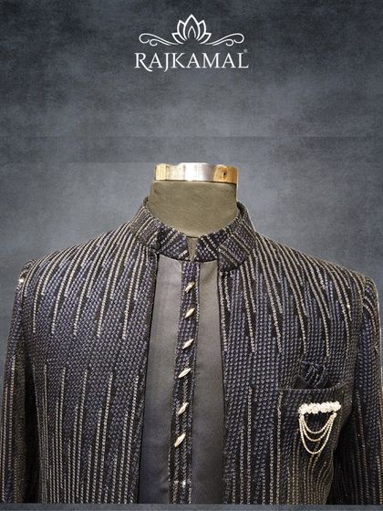 A navy blue Indo-Western jacket with vertical sequin stripes, paired with a matching kurta. This outfit is perfect for a wedding guest or for a cocktail event.