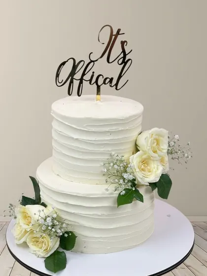 It's official! This two-tiered cake with a rustic textured buttercream finish and fresh white roses is perfect for an intimate yet elegant wedding or engagement party.