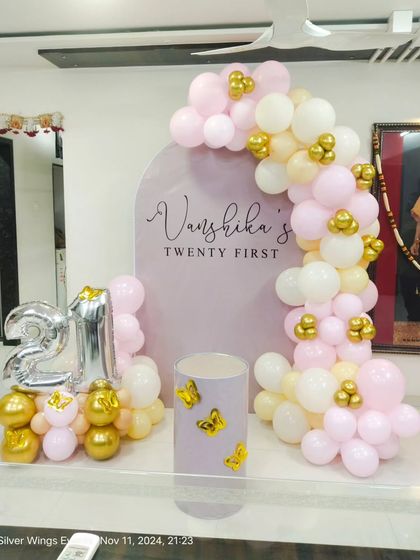 A daytime view of the 21st birthday decor, showing the soft colors and butterfly accents on the cake pedestal.