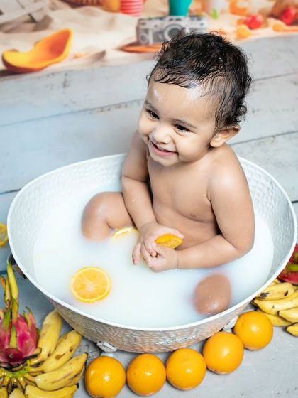 This baby is having a blast in his milk bath, surrounded by fresh fruits. The genuine laughter is what makes these shots so precious.