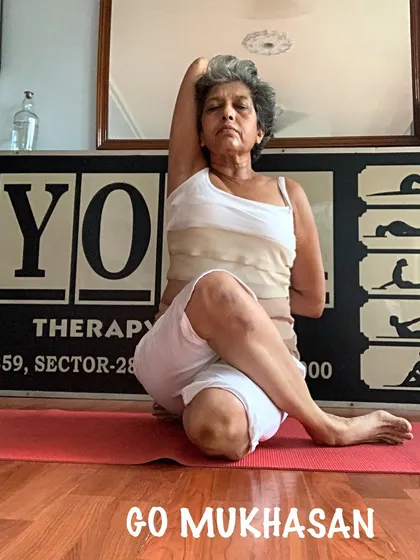 A full Gomukhasana pose, showing both the leg and arm positions. I teach this pose to improve posture and relieve shoulder tension.