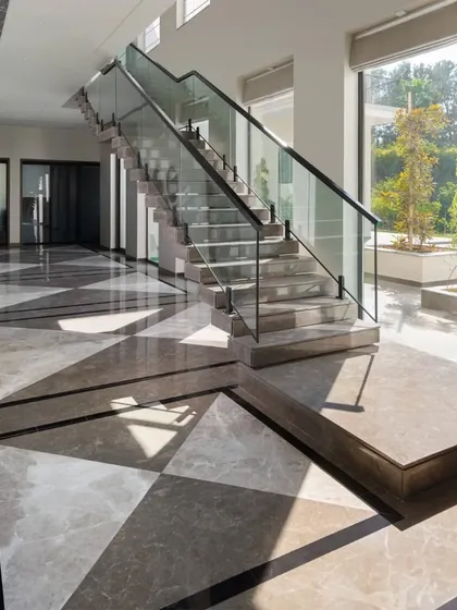 The geometric patterns of the marble floor are highlighted by the strong afternoon sun. We use flooring not just as a surface, but as a design element to create rhythm and visual interest.